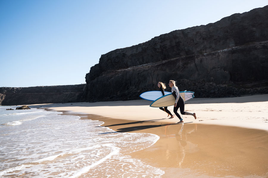 Två kvinnor surfar på Fuerteventura
