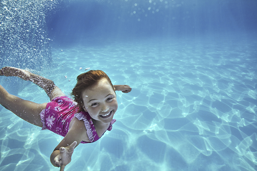 Barn dyker i pool under resa på sportlovet